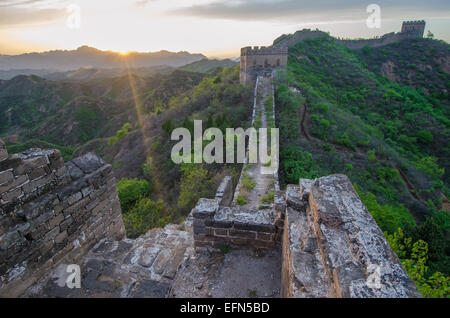Die 2.300 Jahre alte chinesische Mauer wird von der untergehenden Sonne beleuchtet. Stockfoto