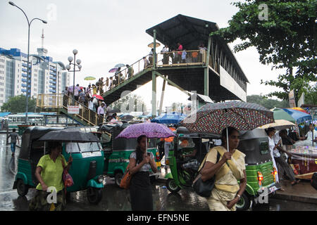 Einheimische mit Regenschirm während starkem Regen Regen während der Regenzeit vor Hauptbahnhof station Colombo, Sri Lanka, Asien Stockfoto