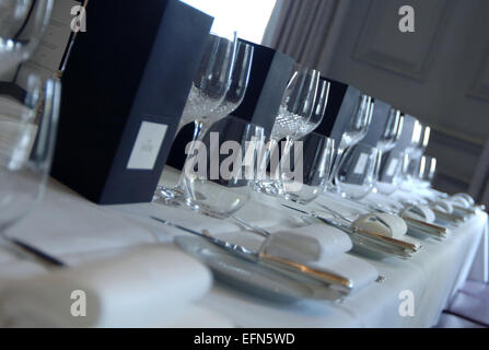 Gedecke auf einem langen Tisch gelegt in ein teures restaurant Stockfoto