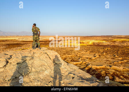 Schwefelsäure-Pools in Dallol in Äthiopien mit einer Wache, die auf einem Felsen Stockfoto