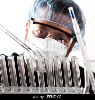 Nahaufnahme eines männlichen Wissenschaftlers Reagenzgläser mit Pipette im Labor zu füllen. Stockfoto