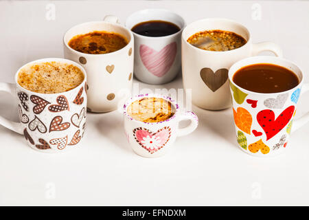 Es gibt viele Kaffee in verschiedenen Bechern mit Herzen. Stockfoto