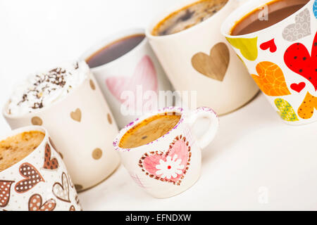 Es gibt viele Kaffee in verschiedenen Bechern mit Herzen. Stockfoto