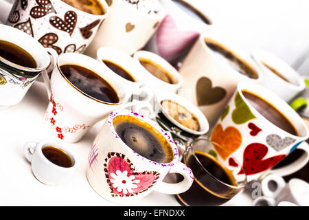 Es gibt viele Kaffee in verschiedenen Bechern mit Herzen und Blumen. Stockfoto