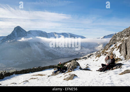 Wanderer ruht auf Weg zu Carneddau Berge über Ogwen Valley mit Blick auf Mount Tryfan im Winter. Snowdonia National Park (Eryri) Wales UK Großbritannien Stockfoto