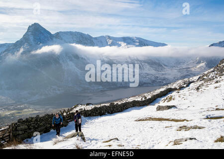 Wanderer auf dem Weg zu Carneddau Berge über Ogwen Valley mit Blick auf Mount Tryfan im Winter. Snowdonia National Park (Eryri) North Wales UK Großbritannien Stockfoto