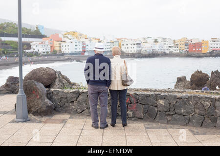 Älteren, ältere paar im Urlaub genießen den Blick auf den Strand und die Bucht von Puerto De La Cruz, Teneriffa, Kanarische Inseln Stockfoto