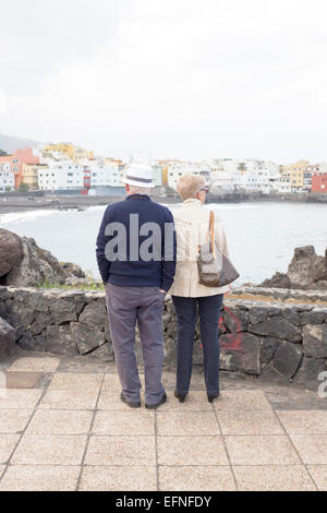 Älteren, ältere paar im Urlaub genießen den Blick auf den Strand und die Bucht von Puerto De La Cruz, Kanarische Inseln Stockfoto