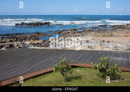 Hölzerne Promenade und felsige Ufer des Atlantischen Ozeans in Porto, Portugal. Stockfoto