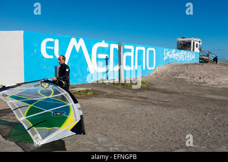 Männliche Windsurfer mit Rig vor der El Medano Wandmalerei, El Médano, Granadilla de Abona, Teneriffa, Kanarische Inseln Stockfoto