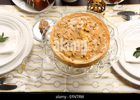Weihnachten-Käsekuchen Karamell mit Muttern an den gedeckten Tisch Stockfoto