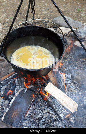 Zubereitung von Essen am Lagerfeuer, Kochen in großen Metall-Kessel Stockfoto