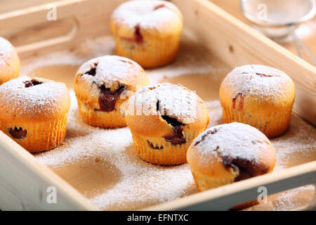 Muffins mit Marmelade bestreut mit Puderzucker auf Tablett aus Holz Stockfoto