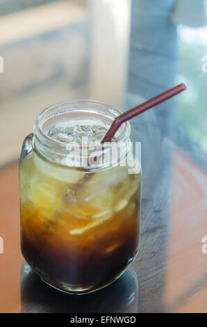 Ein Glas schwarz Eiskaffee mit Strohhalm trinken Stockfoto