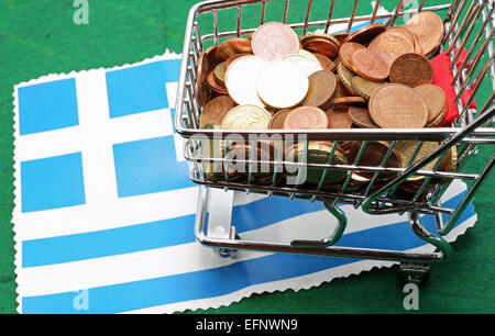 Einkaufswagen voller Münzen Euro über Flagge von Griechenland Stockfoto