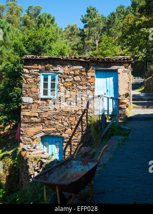 Cerdeira Schiefer Weiler Steinhaus vor der Waldbäume Stockfoto