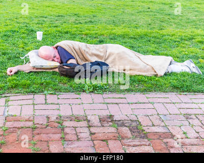 Ein Obdachloser schläft liegen außen auf dem Rasen vor dem Rathaus in Santa Barbara, Kalifornien. Stockfoto