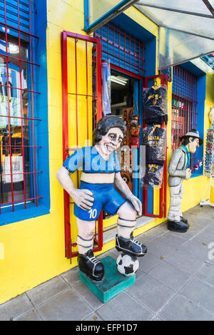 Bildnis des lokalen Fußball-Helden Diego Maradona in den Farben der Boca Juniors außerhalb eines Sport Souvenir shop in La Boca, Buenos Aires, Argentinien Stockfoto