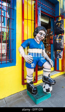 Bildnis des lokalen Fußball-Helden Diego Maradona in den Farben der Boca Juniors außerhalb eines Sport Souvenir shop in La Boca, Buenos Aires, Argentinien Stockfoto