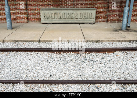 BALTIMORE, Maryland – die Bahngleise verlaufen vor einem alten Steinschild der B&O-Bahn. Das B&O Railroad Museum in Mount Clare in Baltimore, Maryland, verfügt über die größte Sammlung von Lokomotiven aus dem 19. Jahrhundert in den Vereinigten Staaten. Stockfoto