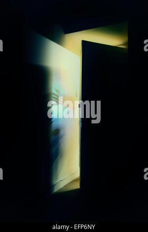 Schatten eines Mannes Öffnen einer Tür in einem dunklen Raum in der Nacht Stockfoto