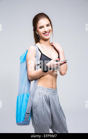 Porträt einer lächelnden Sport Frau stehend mit smartphone Stockfoto