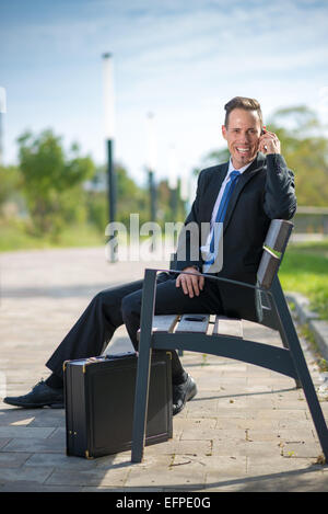 Erfolgreicher Geschäftsmann nannte in einem park Stockfoto