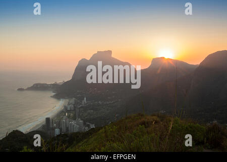 Sonnenuntergang über Pedra da Gavea Berg (Gavea Rock), mit der Nähe von Sao Conrado im Vordergrund, Rio De Janeiro, Brasilien Stockfoto