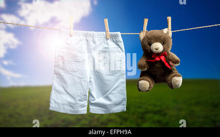 Jungen Hosen, einen Teddybär auf der Outdoor-Wäscheleine Stockfoto