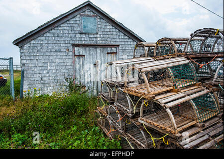 Reusen vor einer Schindel-Hütte im Hafen von Neils, Cape Breton Highlands NP, Cape Breton Island, Nova Scotia, Kanada Stockfoto