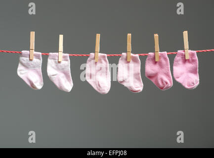 Babymädchen Socken auf der Wäscheleine Stockfoto