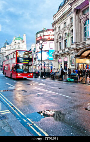 London, Vereinigtes Königreich - 12. April 2013: Piccadilly Circus Neon Schilder spiegelt sich auf der Straße mit typischen Doppeldeckerbus Stockfoto