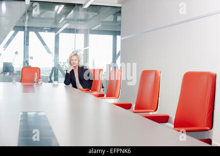 Frau sitzt auf orange Stuhl im Konferenzraum Stockfoto