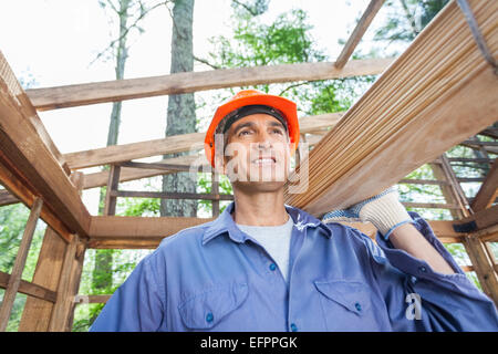 Bau Arbeiter mit Holzbohlen Stockfoto