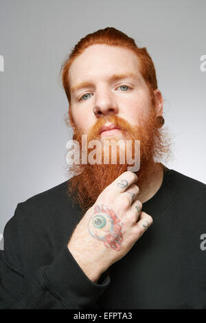 Studio-Porträt der jungen Mann mit roten Haaren streichelte Bart Stockfoto