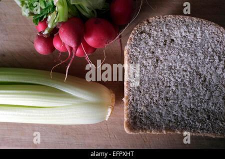 Radieschen Sellerie und Brot auf ein Schneidbrett aus Holz hautnah Stockfoto