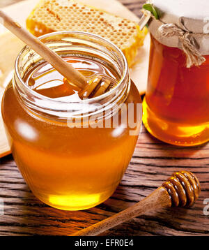 Hölzerne Wagen im Glas kann der Honig auf Holztisch voll. Stockfoto