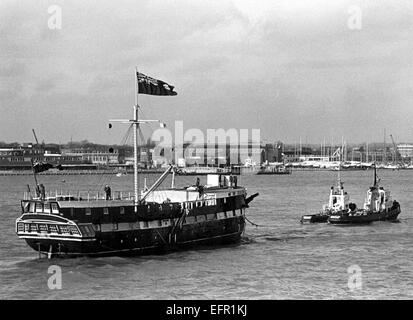 AJAXNETPHOTO. 21. JANUAR 1977. PORTSMOUTH, ENGLAND. -HOLZWAND KEHRT ZURÜCK - T.S. FOUDROYANT (EX TRINCOMALEE) UNTER EINGABE VON TOW HAFEN NACH DEN LETZTEN REFIT. FOTO: JONATHAN EASTLAND/AJAX REF: 2772101 Stockfoto