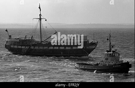 AJAXNETPHOTO. 21. JANUAR 1977. PORTSMOUTH, ENGLAND. -HOLZWAND KEHRT ZURÜCK - T.S. FOUDROYANT (EX TRINCOMALEE) UNTER EINGABE VON TOW HAFEN NACH DEN LETZTEN REFIT. FOTO: JONATHAN EASTLAND/AJAX REF: 2772101 25 19 Stockfoto