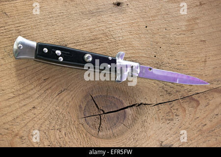 Switchblade Messer auf Holz Hintergrund Stockfoto