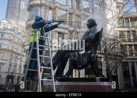 London, UK. 9. Februar 2015. Umgeben von modernen Büros in der Nähe der Bank of England in Cornhill, ein Restaurator mit City of London Auftragnehmer Rupert Harris Erhaltung off verwendet ein Druck-Jet spray Schlauch die Statue des viktorianischen Philanthrop, Unternehmer und Banker George Peabody (1795 bis 1869). Als Teil eines kontinuierlichen Wartung und Reinigung durch die quadratische Meile Körperschaft, historische Objekte - aus Hunderten von Statuen und Gedenktafeln an anderen Stücken von historischem Wert sind regelmäßig besucht. Stockfoto