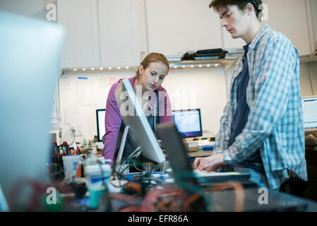 Zwei Menschen, Mann und Frau stehen an der Theke in einem Computer-Werkstatt. Stockfoto