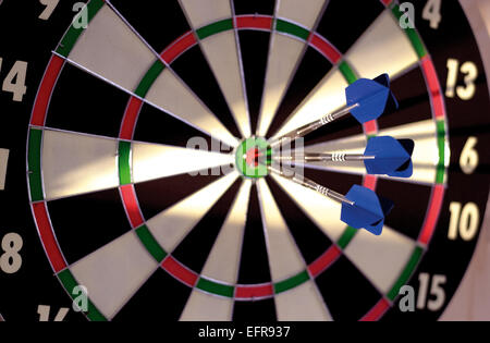 Dartscheibe mit Darts im Zentrum Stockfoto