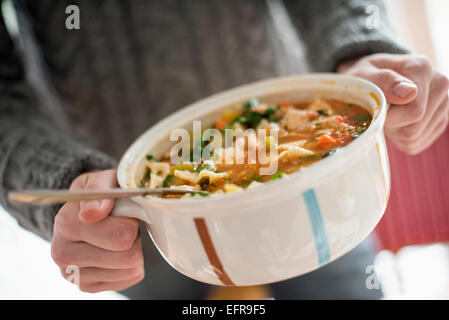 Nahaufnahme eines Mannes hält eine Schale mit einem Gemüseeintopf. Stockfoto