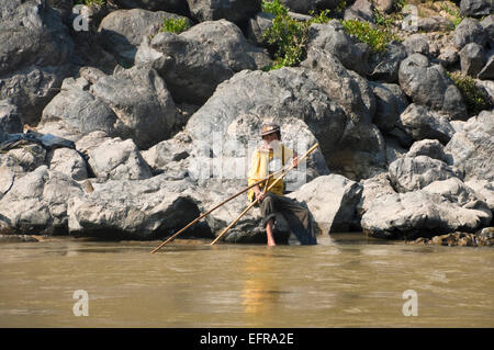 Horizontale Bildniss eines alten Lao Mann Angeln mit hausgemachten Netze an den Ufern des Mekong-Flusses. Stockfoto