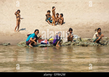 Horizontale Ansicht von einer Gruppe von Kindern spielen und entspannen an den Ufern des Mekong-Flusses. Stockfoto