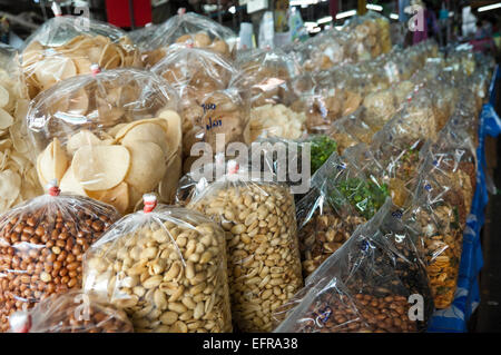 Horizontale Nahaufnahme von Reihen von Plastiktüten voller Nüsse und getrocknete Snacks in Thailand. Stockfoto