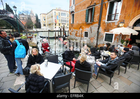 Menschen sitzen in einem Café neben der Ponte Dell Accademia-Brücke in Venedig, Italien. Stockfoto
