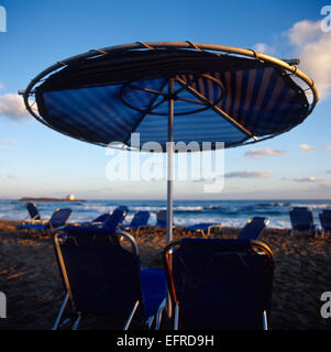 Liegestühle und Sonnenschirm am Strand an einem Vormittag Stockfoto