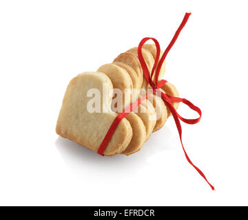 Cookies in Form von Herzen, gebunden mit rotem Band auf weißem Hintergrund. Isoliert mit Beschneidungspfad. Stockfoto